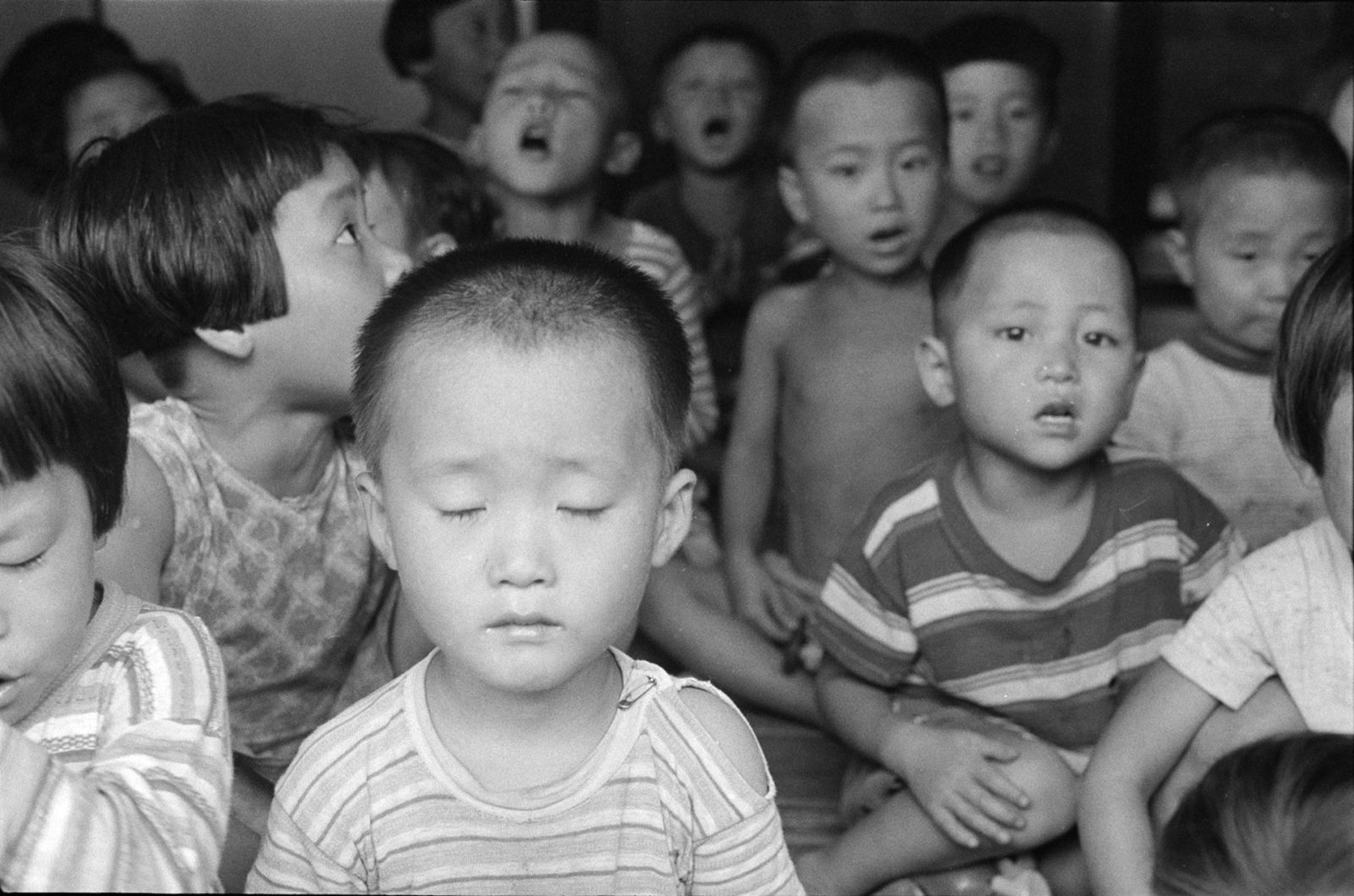Dorothea Lange's photograph titled Korean Child, 1958, depicts a group of excited students in a crowded South Korean classroom