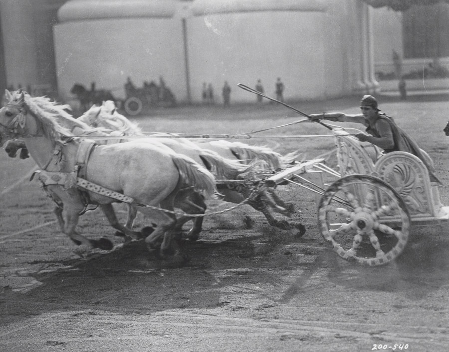 Black and white film still from Ben-Hur (1925) showing a man on a horse-drawn chariot