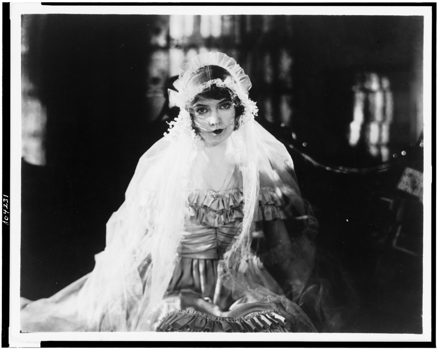 Black and white film still from Way Down East (1920) showing a seated woman wearing a ruffled gown and veil.